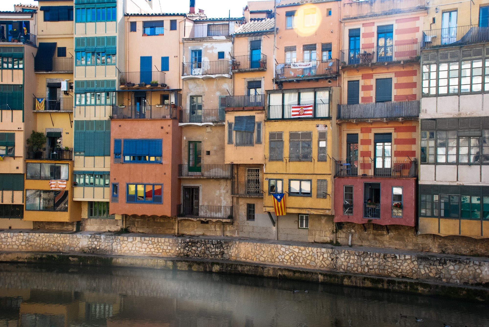 Pastel coloured buildings follow the curve of the Onyar River, Girona, Catalonia