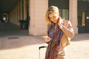 young modern business woman arrived in a European city checking a mobile travel app.